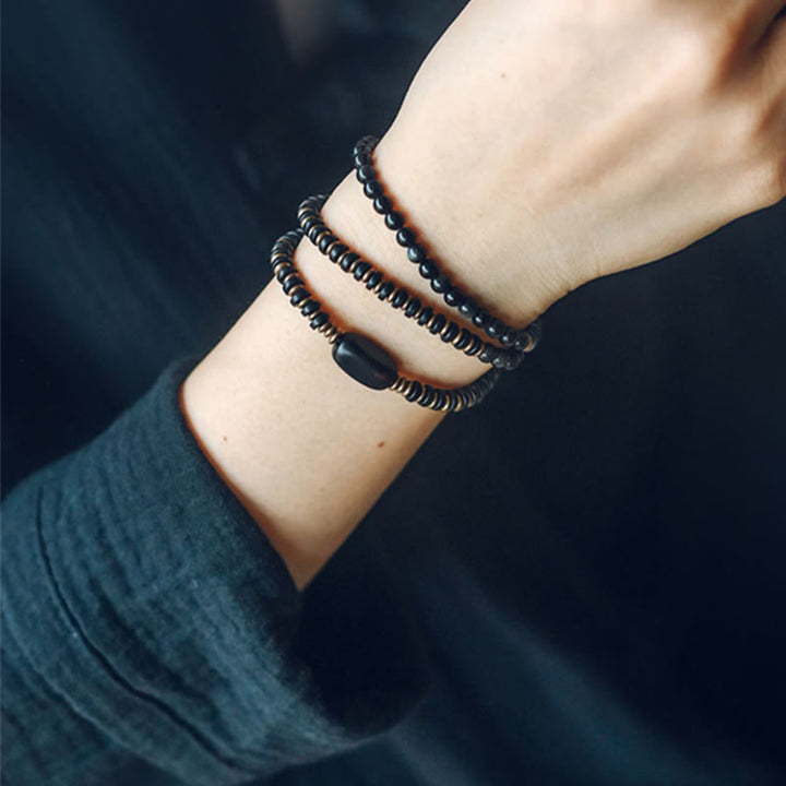 Bransoletka lecznicza z Buddha Stones, tęczowym obsydianem, drewnem hebanowym i miedzią, potrójnie owinięta