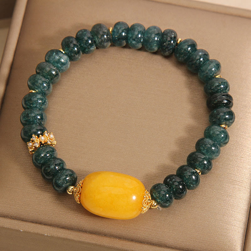 Bransoletka z Buddha Stones, zielonych jadeitowych koralików Abacus i topazu, z której można uzyskać szczęście