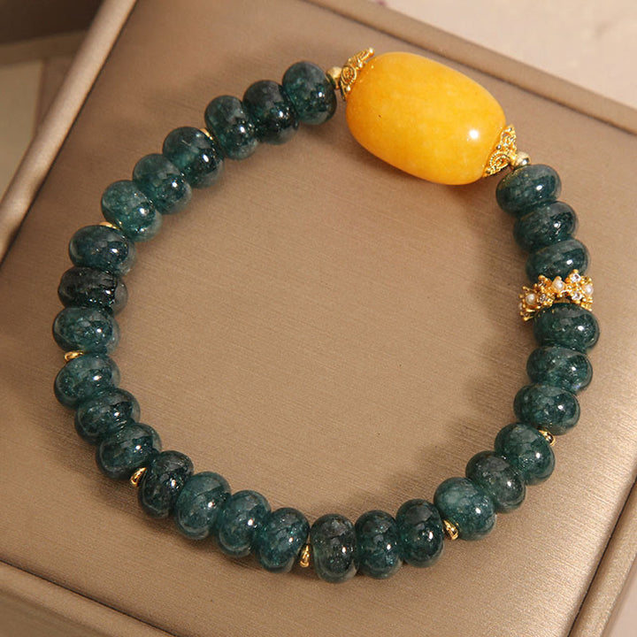 Bransoletka z Buddha Stones, zielonych jadeitowych koralików Abacus i topazu, z której można uzyskać szczęście